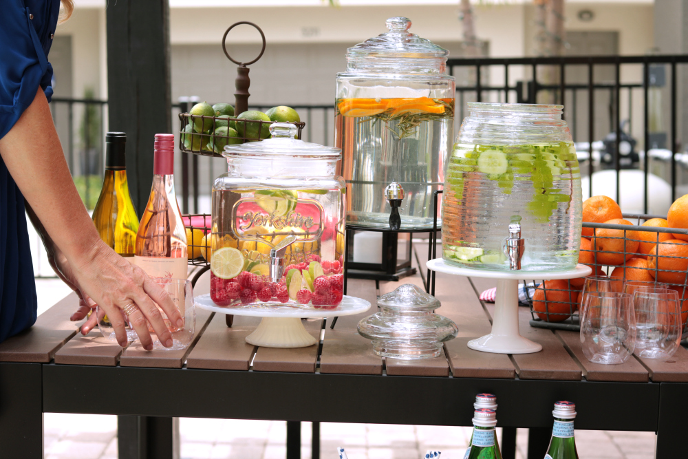 Glasses, Straws And Punch In Glass Dispenser On Garden Table