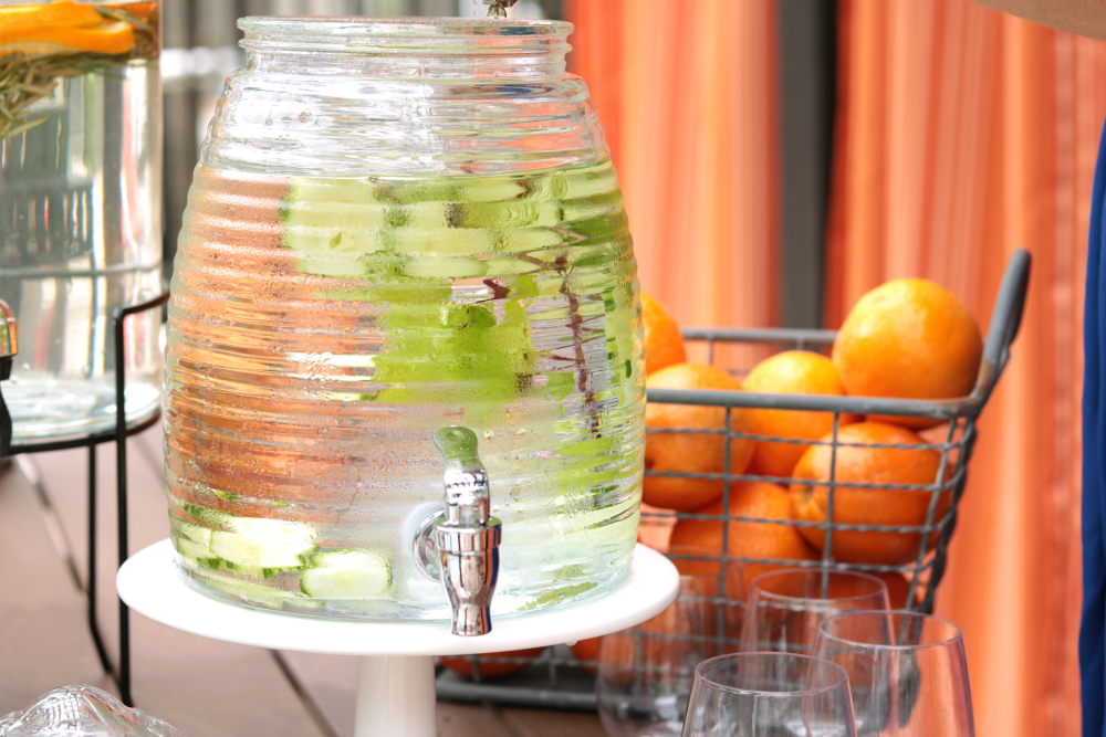 Glasses, Straws And Punch In Glass Dispenser On Garden Table